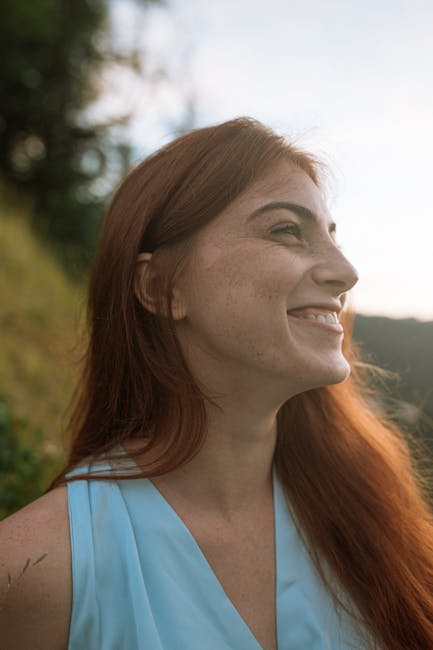 Headshot of a happy smiling woman with dark hair outdoors